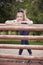 One young beautiful woman, 25 years old, sad portrait, leaning on wooden fence, outdoor in park