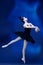 One young incredibly beautiful woman, ballerina in black ballet outfit, tutu dancing at blue studio full of light.