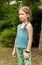 One young proud confident school age girl smiling, happy child wearing a fitness band outside, fit smart watch, standing straight
