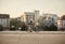 One young smiling man, 20-29 years old, wearing hipster suit, smart casual, sitting on old city bike. city buildings panorama