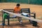 One young sportswoman, professional tennis player with phone on tennis court in bright summer day.