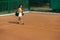 One young sportswoman, professional tennis player walking on clay court in bright summer day.