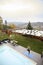 One young woman,20-29 years old, doing yoga tree pose, in a backyard of a fancy house that has a beautiful view of a mountain