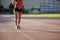 One young woman, unrecognizable person, wearing fitness clothes, walking on a sports court.