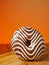 One zebra pattern doughnut on a wooden board and table, Warm orange sunny color background