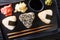 Onigiri in sesame served with ginger, wasabi and sauce close-up on a plate. horizontal top view