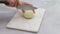 Onion on marble cutting board. Woman hands cut onion