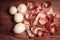 Onion peeled and skin on wooden background