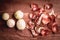 Onion peeled and skin on wooden background