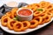 onion rings on a long platter with a side of ketchup