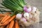 Onions and carrots on wooden background and sack