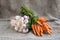Onions and carrots on wooden background and sack