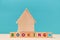 Online booking. Mortgage. Accommodation for rent or sale. Wooden building on blocks with colourful letters. Copy space