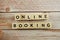 Online Booking word alphabet letters on wooden background