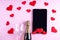 Online congratulations on Valentine's Day. Champagne bottle, wine glass, black tablet screen on a pink background