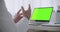 Online consulting with doctor, laptop with green screen for chroma key technology on table and gesticulating hands of