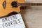 Online courses text online courses in white board for online guitar lessons over a wooden background