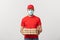 Online delivery and Coronavirus Concept. Cheerful young deliveryman in face mask holding pizza boxes while isolated on