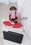 Online education. Girl learns to play guitar at home using laptop.