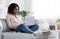 Online Education. Young Black Woman Studying With Laptop On Couch At Home