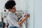 Online english course. Side view of a young afro american female teacher writing on a whiteboard while teaching English