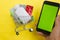 Online pharmacy. Closeup of hands on a phone and a mini shopping trolley with tablets. A woman chooses medicines on the