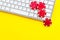 Online poker. Chips near keyboard on yellow background top-down copy space