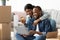 Online Shopping. Cheerful Black Spouses With Laptop Choosing Furniture After Moving Home