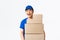 Online shopping, fast shipping concept. Upbeat smiling asian delivery man in blue courier uniform holding boxes with