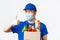 Online shopping, food delivery and covid-19 pandemic concept. Winking cheerful asian male courier in medical mask
