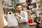 Online shopping. Handsome male blogger holding paper shopping bag and looking at camera while live streaming