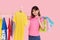 Online shopping. Young asian woman with shopping bags tries on colorful fashion clothes in the store.