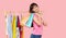 Online shopping. Young asian woman with shopping bags tries on colorful fashion clothes in the store.