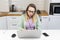 Online teacher woman wearing a headset and using modern laptop. Adult white female person in early 40s working on notebook pc at