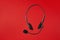 Online technical support service. Call center, helpline. Headphones with microphone on red background