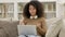 Online Video Chat on Laptop by Young African Woman on Sofa