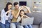 Online video chat online. Family holds hands in the shape of a heart welcomes waving friends using laptop at home.