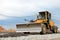 Ð¡onstruction machine Motor Grader at a construction site level the ground and gravel stones for the construction of a new asphalt