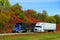 Ontario, Canada - October 27, 2019 - Two large trucks speeding on Route 401 highway with stunning colors of fall foliage