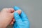 Onycholysis of woman`s hands. The doctor examines a female patient with a problem of delamination of fingernails on a gray