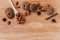 Ð¡ookies with chocolate, cinnamon and almonds with star anise star, white wooden spoon, on a light brown wooden board.