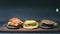 Ð¡ooking two black burgers and one cheeseburger on a black background in 4k resolution time-lapse