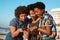 Ooo, look at that picture. three attractive young women huddled together and looking at a cellphone on the beach during