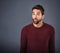 Oooh...thats interesting. Studio shot of a handsome young man looking surprised against a gray background.