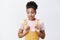 Oops sorry, doest it hurt. Portrait of nervous cute African American girlfriend in yellow overalls, stooping and