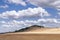 Oostduinkerke, Belgium - June 19, 2019: Wide beach view with paraglider and clouds partially blocking the sun