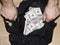 Op view of man`s hand open Full Black Duffel Bag of Hundred Dollar Bills