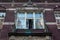 Open aged shabby window with bas-reliefs on one of the historic buildings in the Main Town of Gdansk.