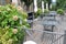 Open-air cafe in the garden with empty iron furniture on wooden terrace