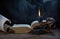 An open ancient book, a burning candle in a dark candlestick, and unfolded and rolled scrolls on a wooden table in a haze